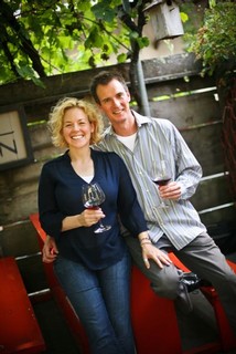 Alan and Serena sitting on a table with a glass of wine